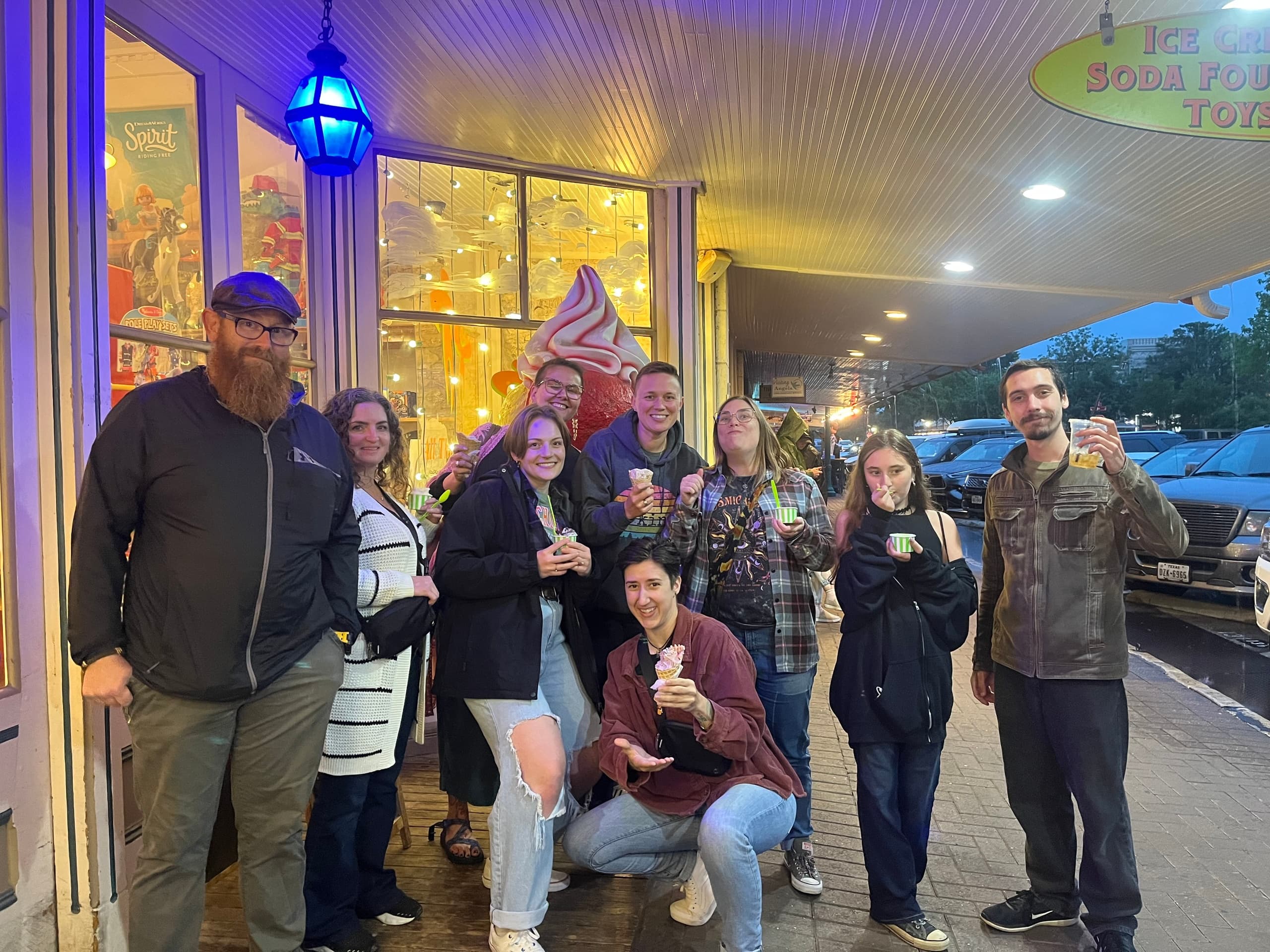 Group enjoying evening ghost tour outside historic ice cream shop