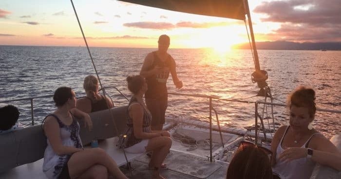 Sunset sailing trip aboard catamaran, passengers enjoying ocean views