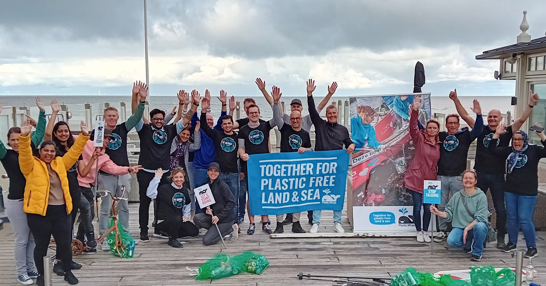 Volunteer group holding banner for plastic-free shoreline