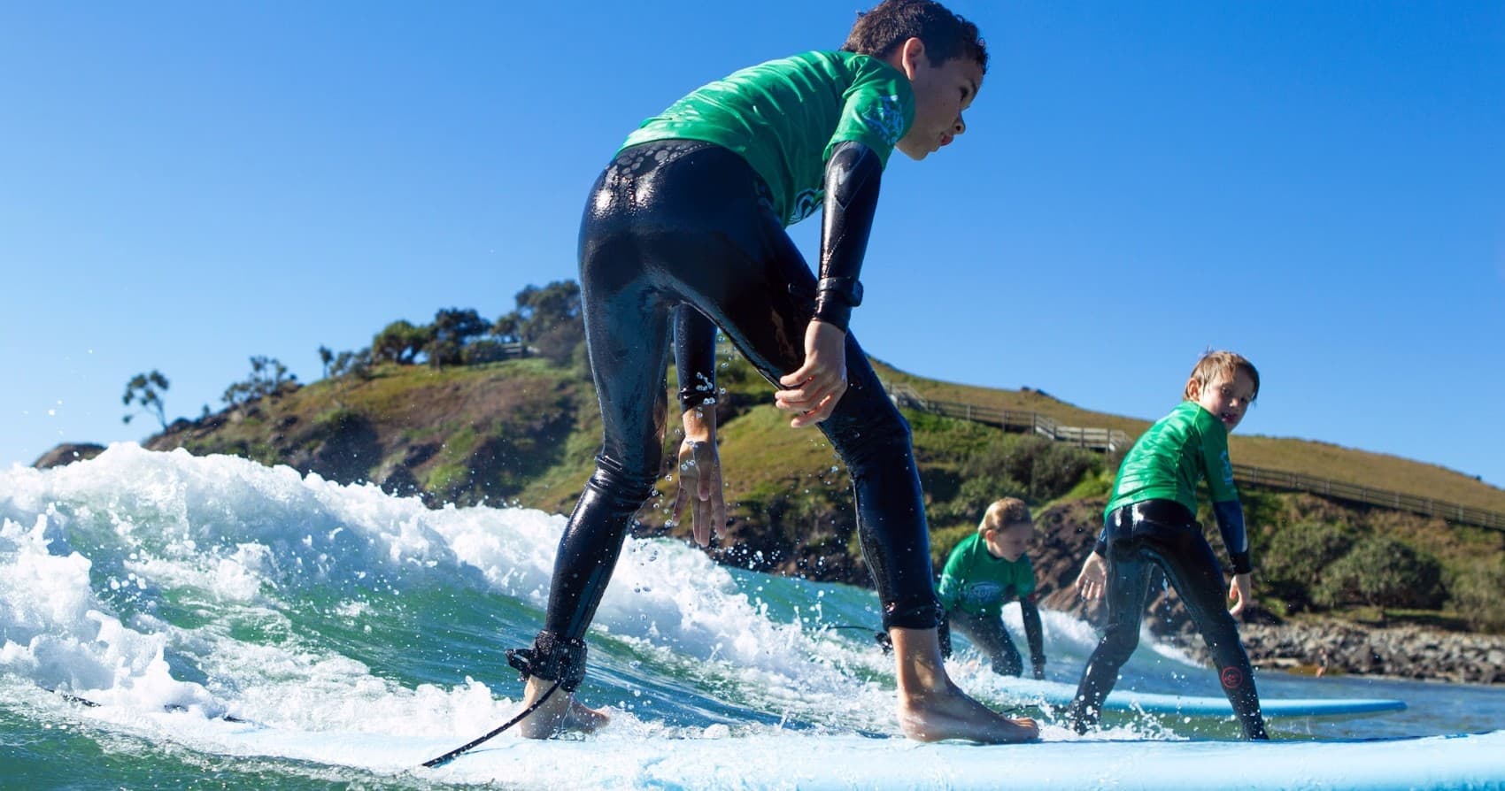 Group surf lesson with instructor guiding students on waves