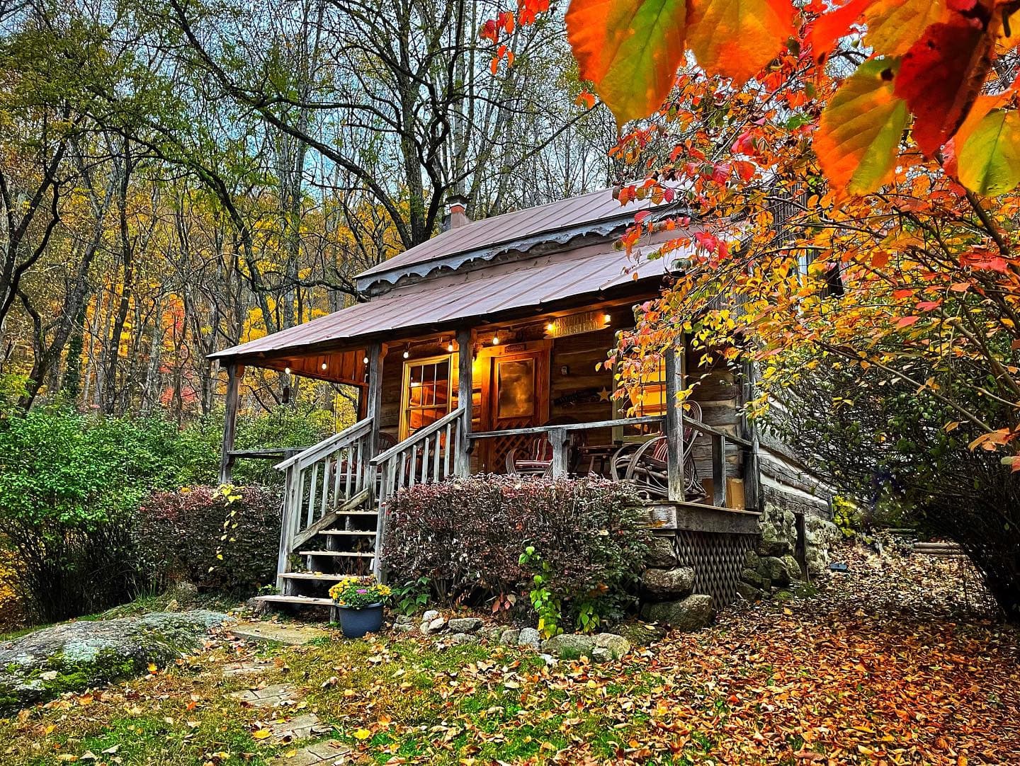 Autumn woodland cabin with porch and colorful foliage at Crabtree
