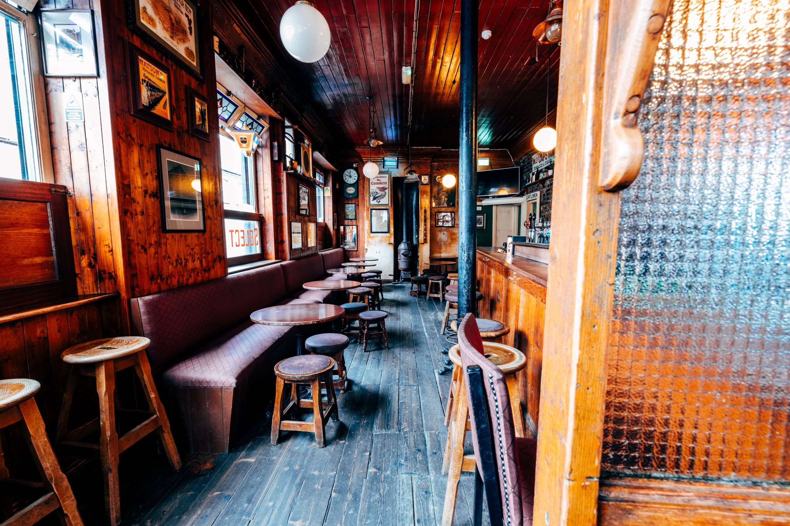 Whiskey tasting inside cozy wooden Irish pub, guests sampling drams