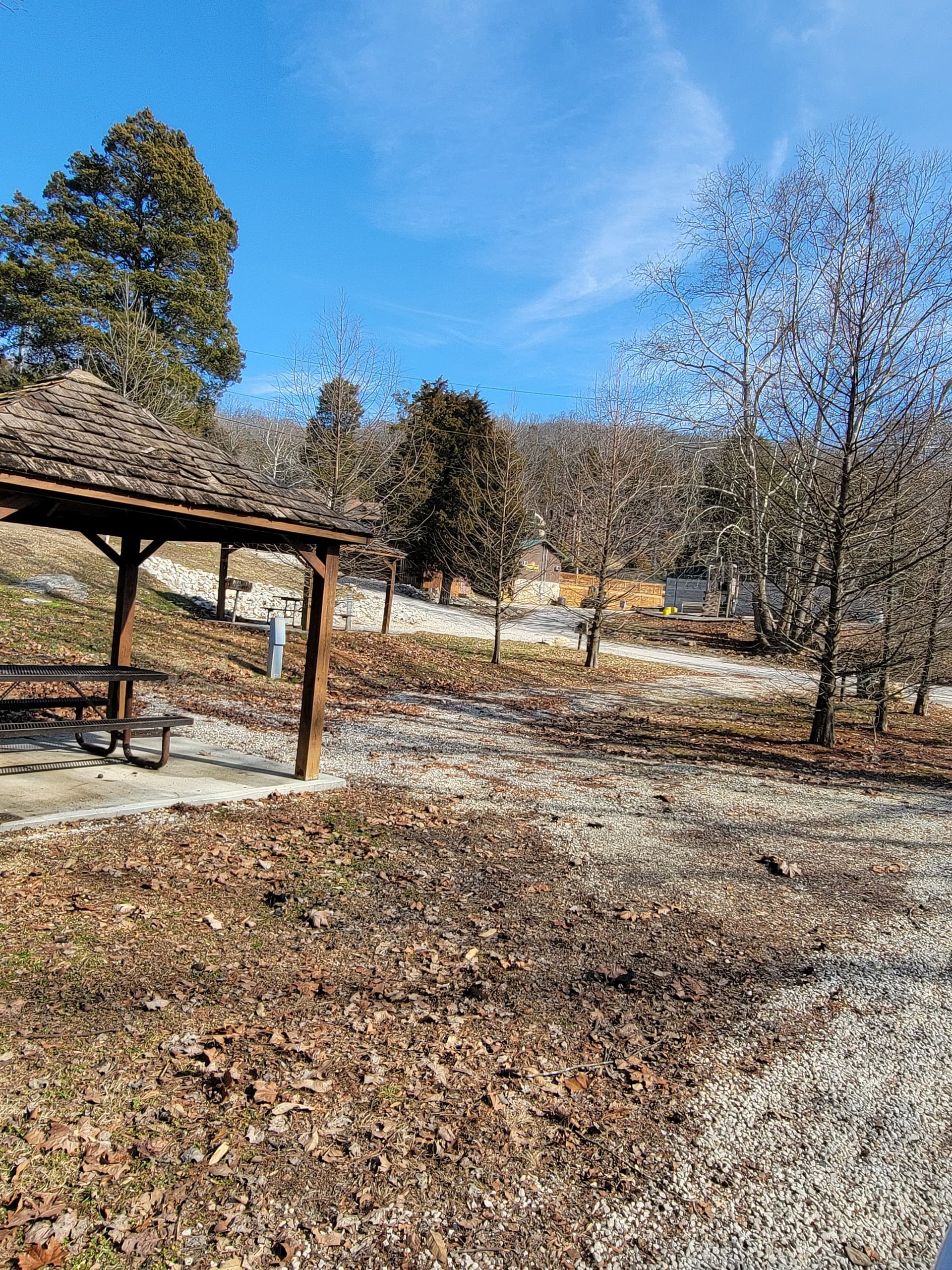 Gravel campground road with picnic shelters and winter trees view