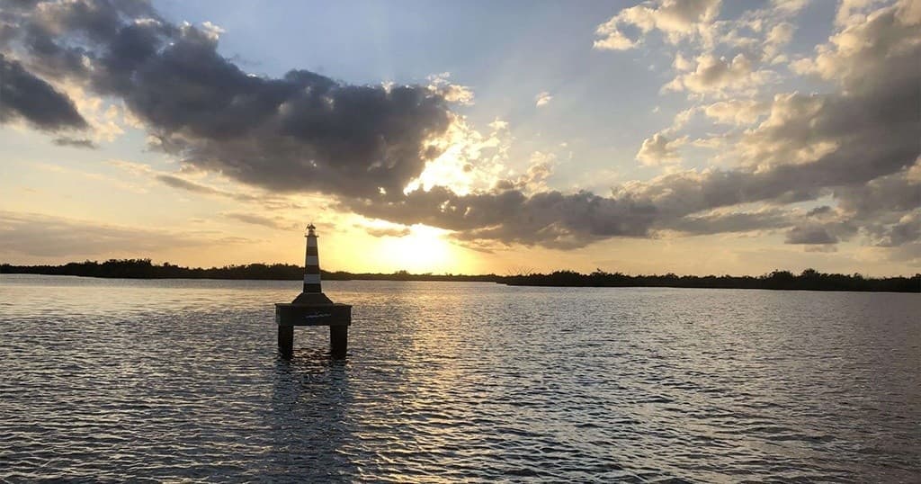 Sunset over river with marker buoy and reflective water