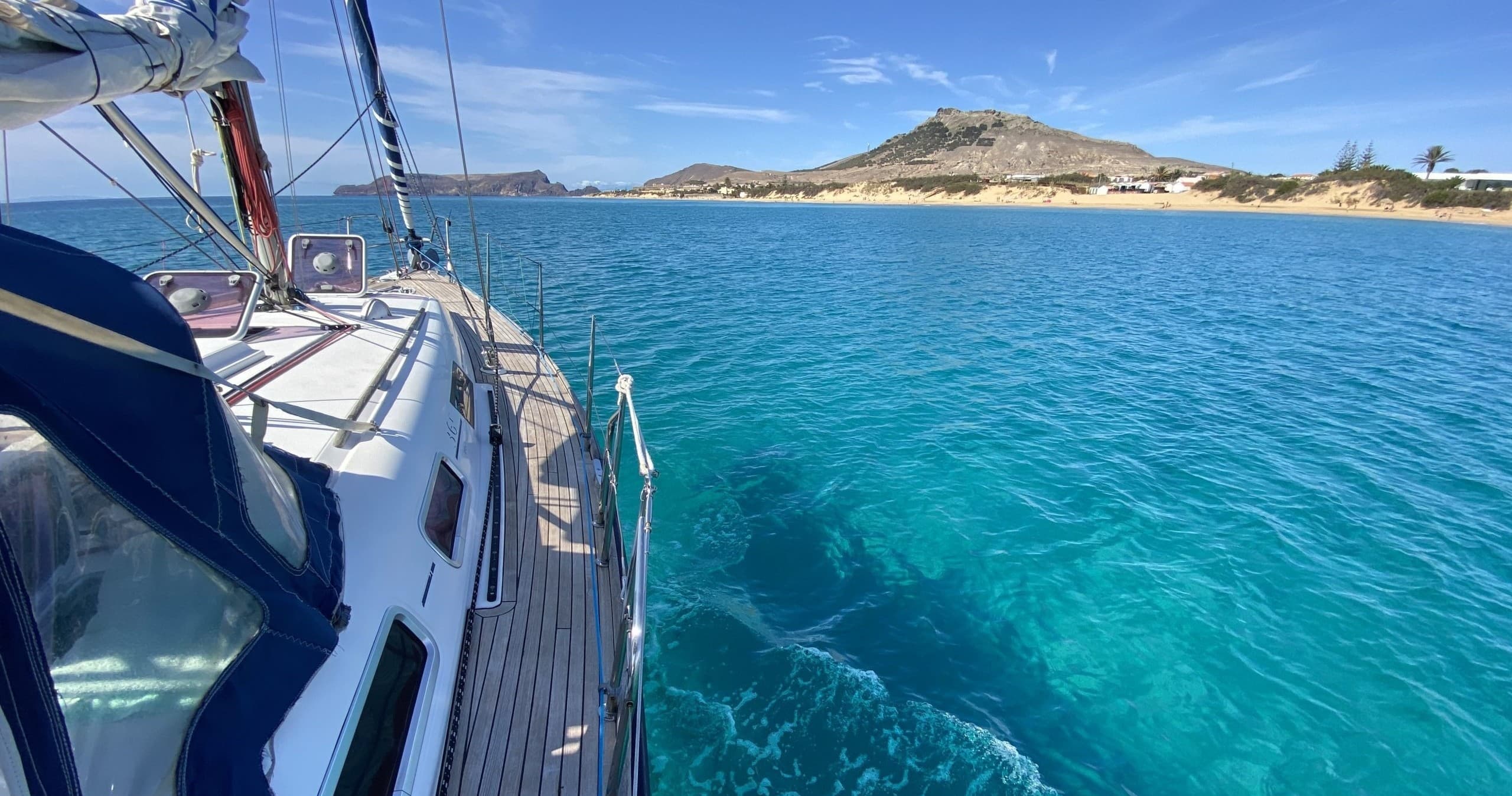 Sailing along crystal clear turquoise shore with island vista