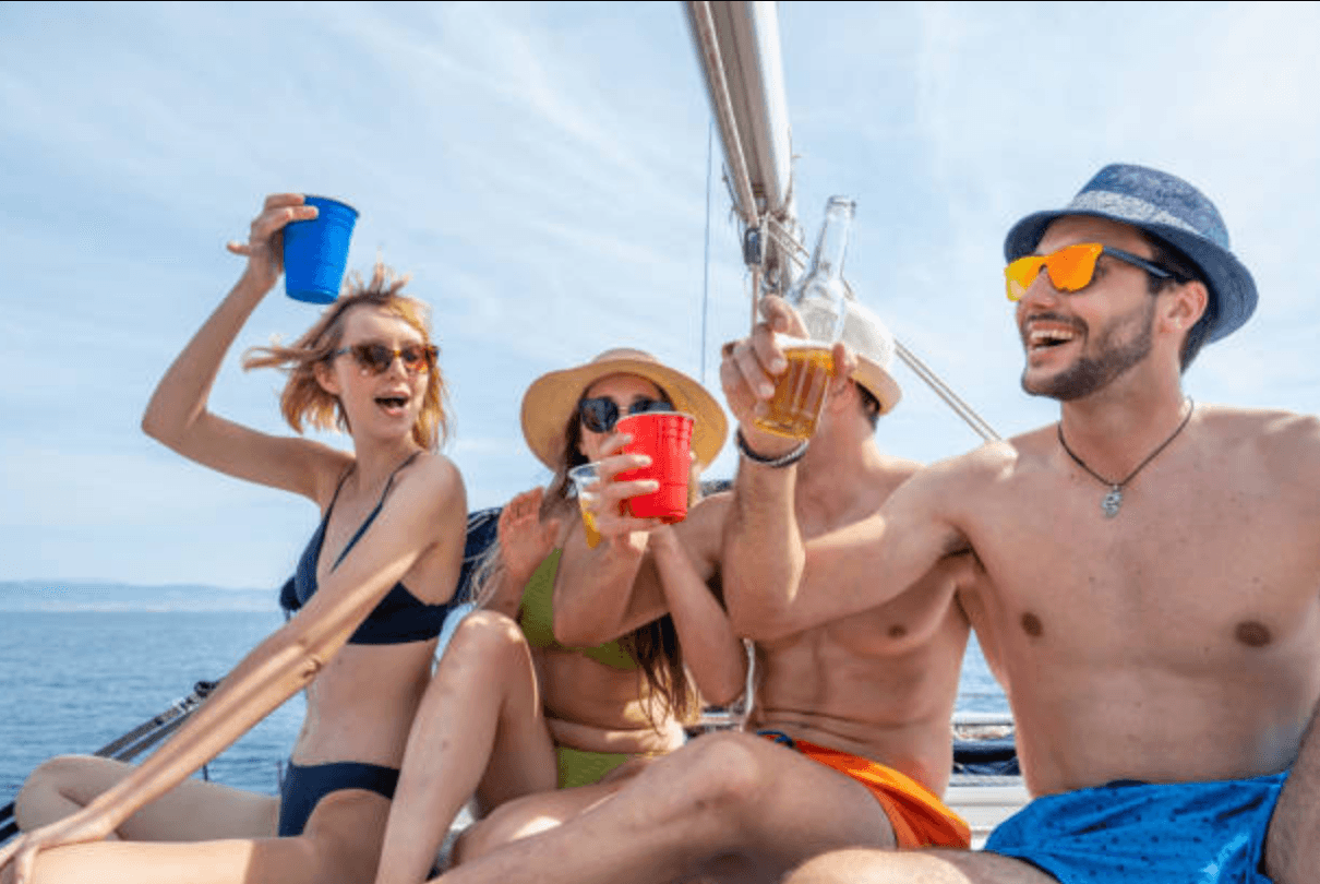 Friends partying on sailboat under sunny tropical sea sky