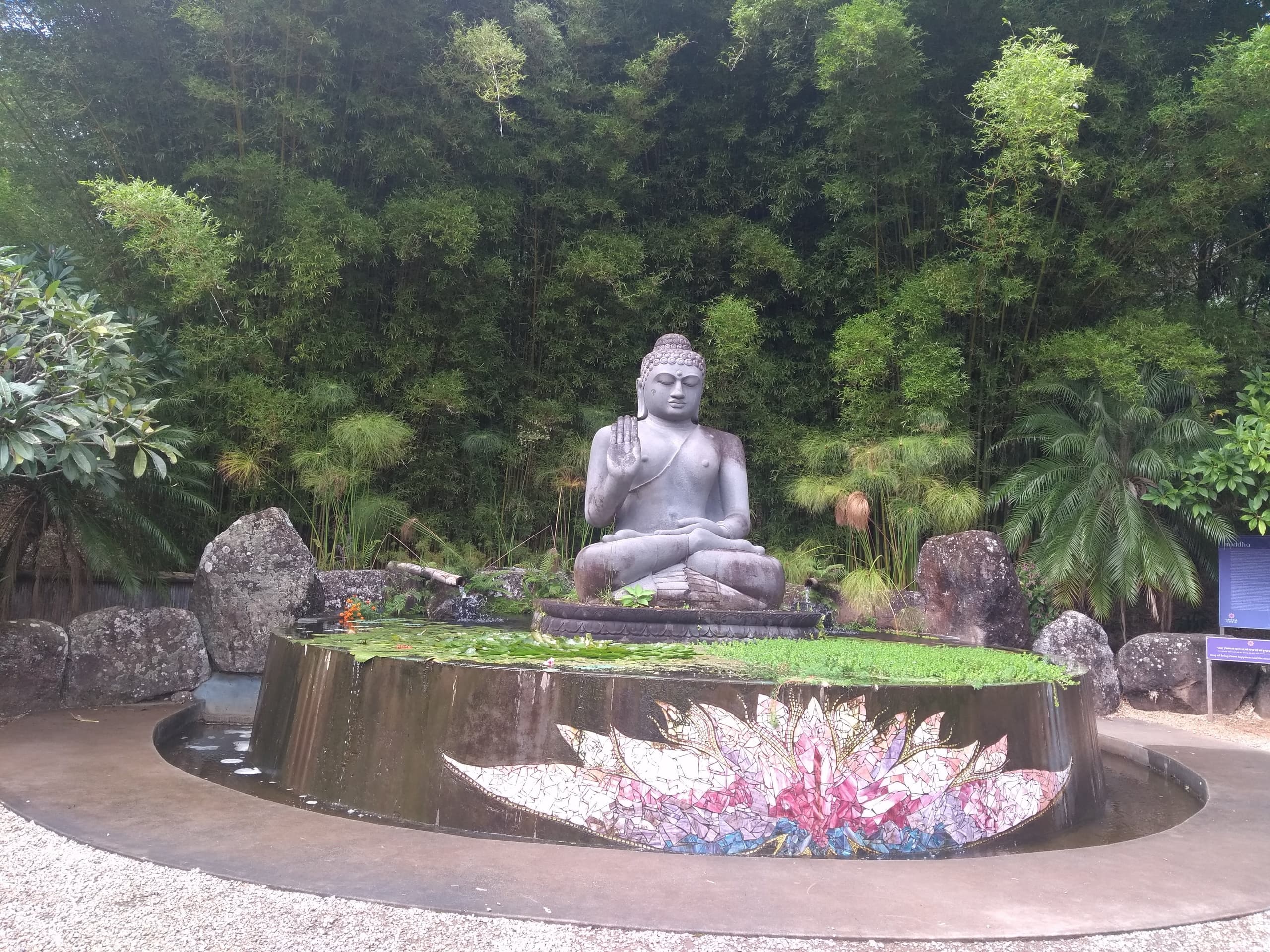 Buddha statue and fountain in tropical garden meditation retreat setting