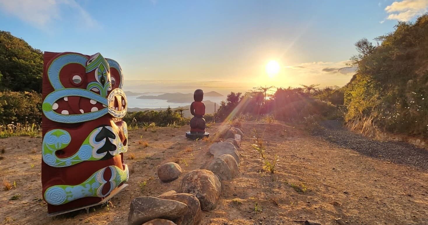 Carved totem poles along coastal trail at sunset scenic viewpoint