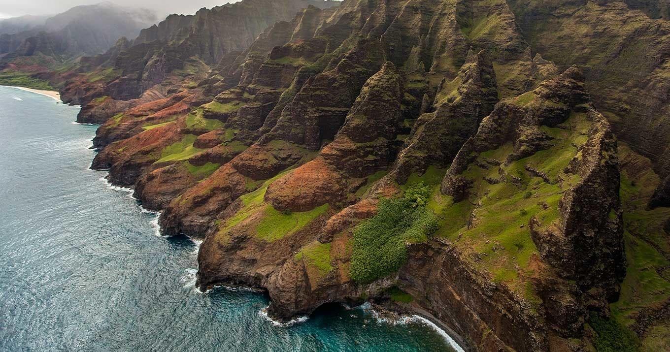 Panoramic Na Pali Coast helicopter aerial of cliffs and shoreline