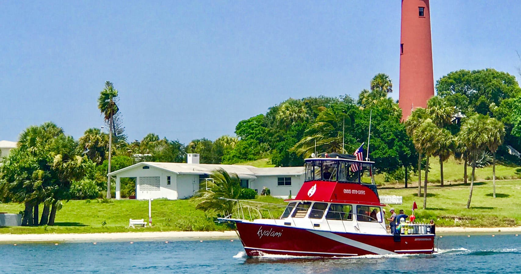 Tour boat passing Jupiter inlet lighthouse and shoreline views