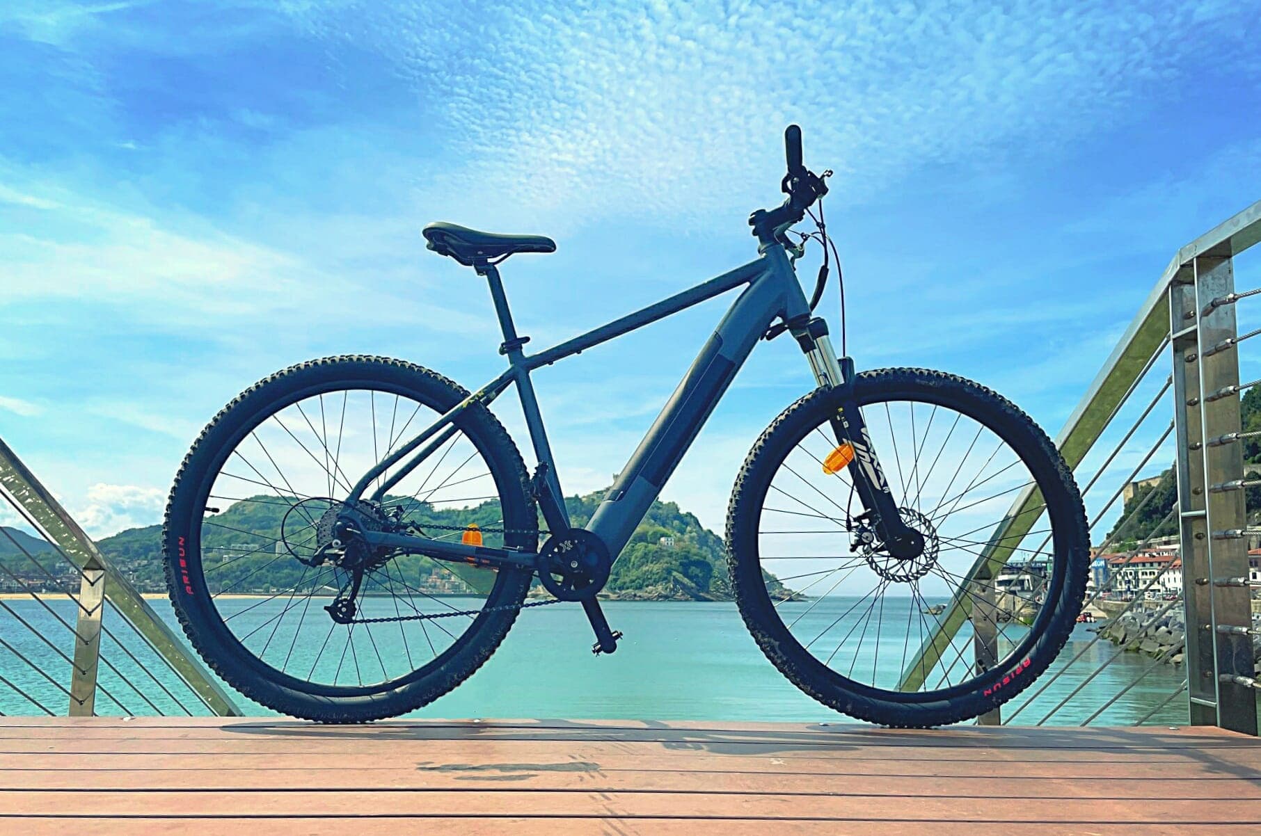 Mountain bike silhouetted on seaside boardwalk at sunrise