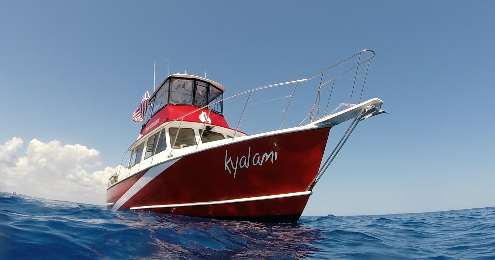 Red dive boat on calm blue ocean waters near Jupiter, day trip