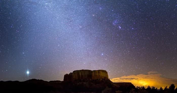 Stargazing under Milky Way over rugged mesa at night