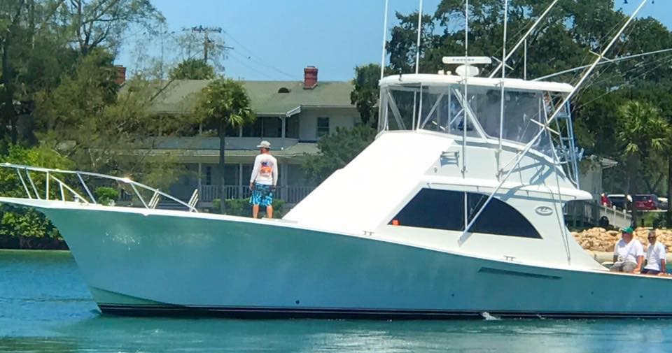 Sportfishing boat cruising coastal waters, clear sky and dockside view