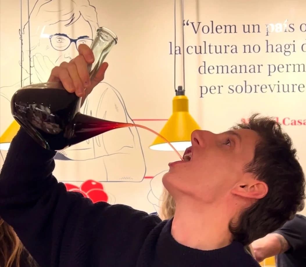 Man sampling red wine from decanter in indoor Girona tasting room