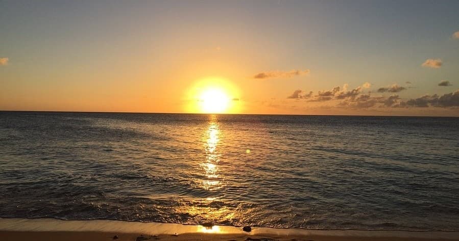 Ocean sunrise over calm sea, peaceful beachfront morning