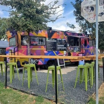 Colorful Austin food truck with outdoor seating at park event