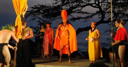 Hawaiian luau ceremony on oceanfront stage at sunset