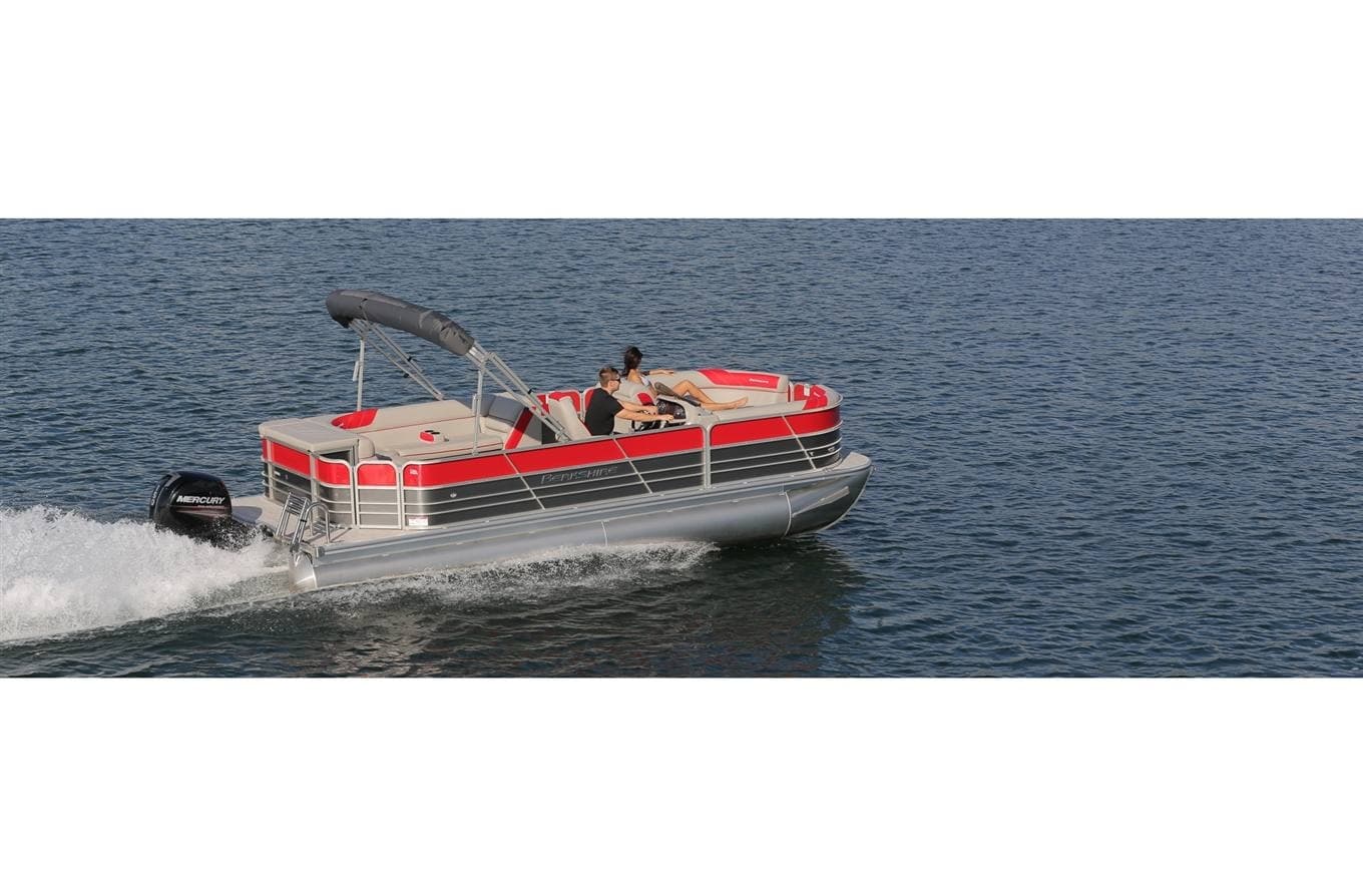 Red pontoon boat speeding across open lake water outdoors