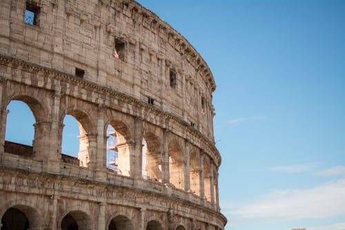 Sunlit Colosseum exterior arches in Rome historic landmark