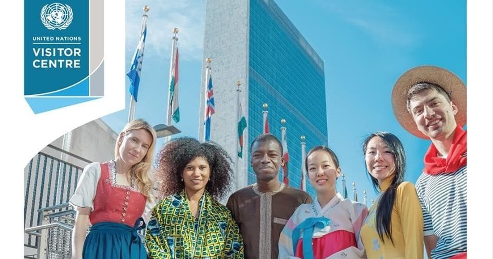 Tour group posing outside UN headquarters with flags, NYC