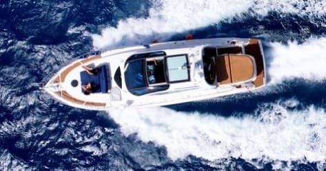Aerial view of yacht cutting through deep-blue ocean waves