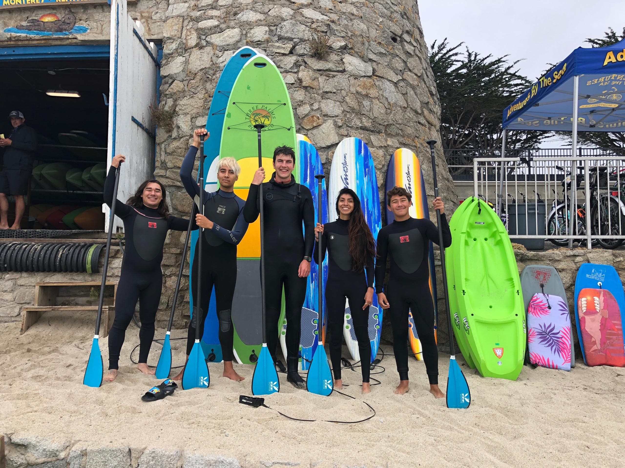 Surf lesson group posing with boards at Lovers Point beach