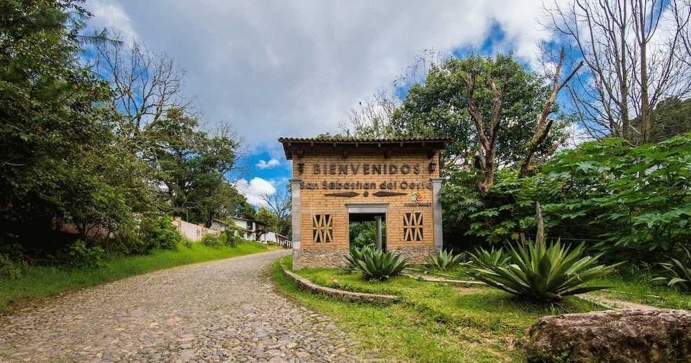 Scenic rural welcome arch and gravel road into jungle