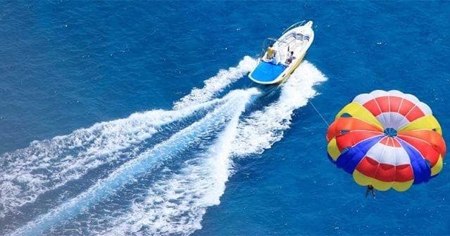 Parasail boat towing colorful parachute over blue ocean