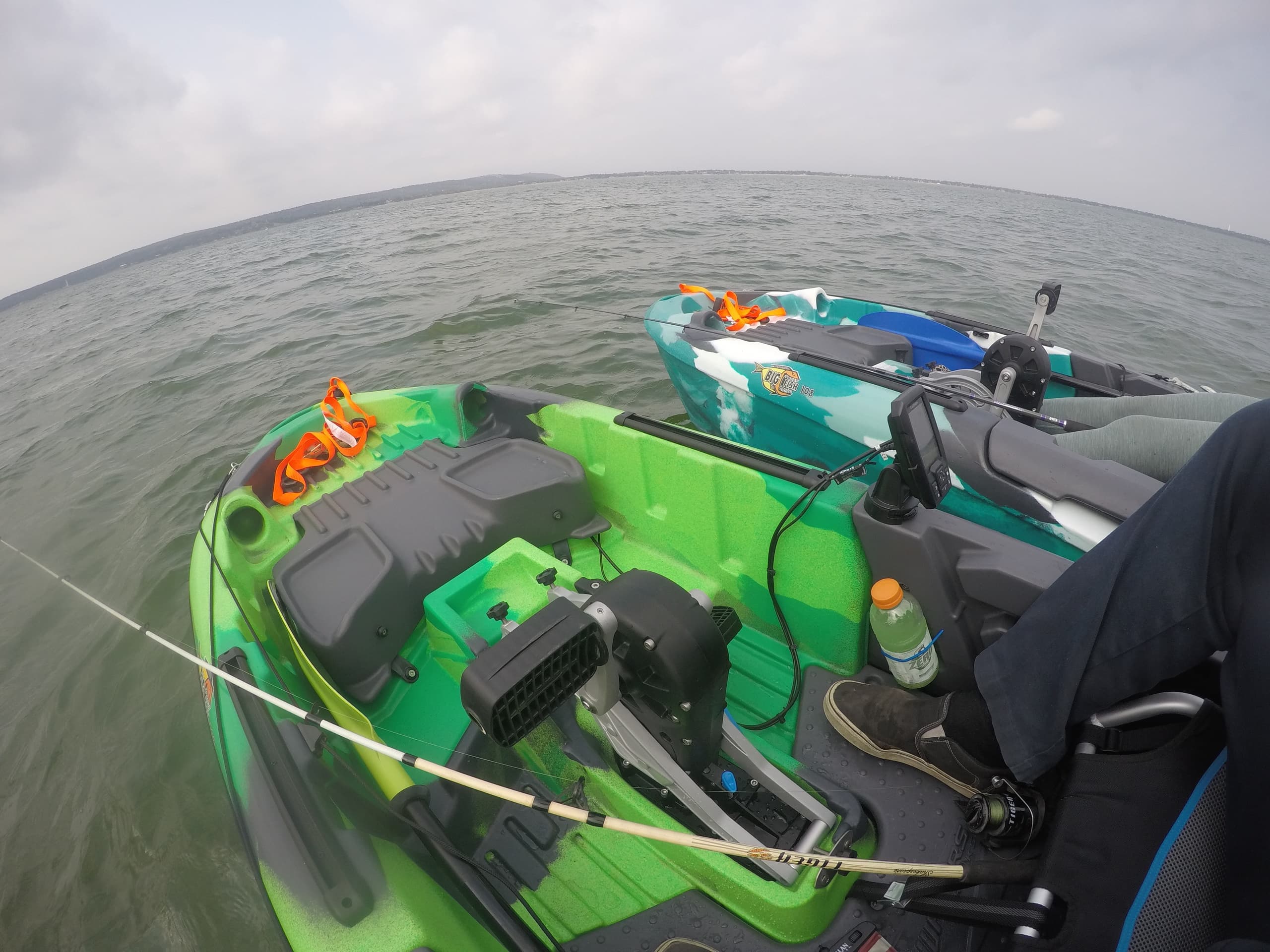 Angler's kayak deck with gear on choppy open water