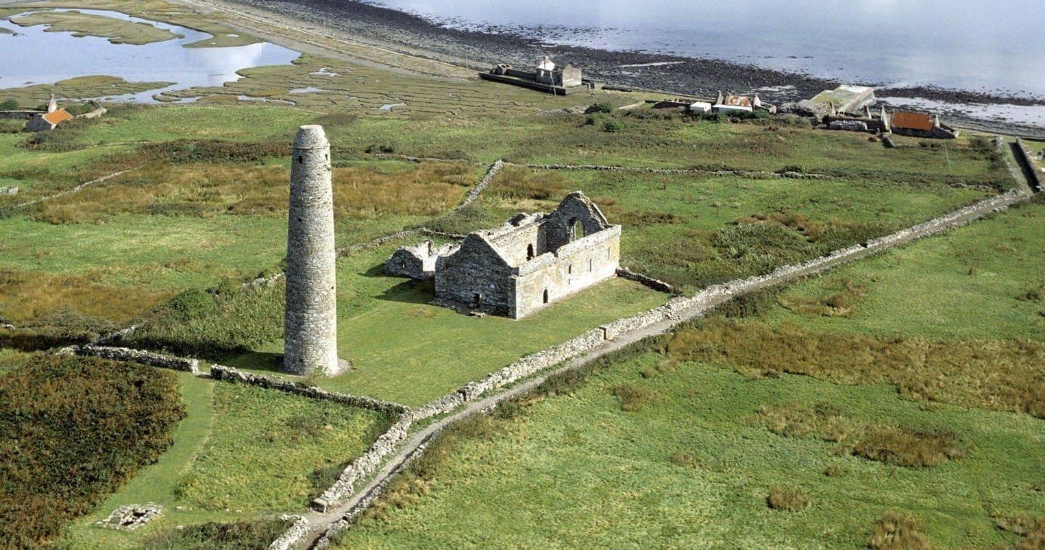 Aerial view of Scattery Island round tower and grassy shore