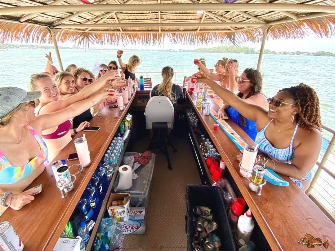 Crowded floating bar with guests toasting on sunny estuary cruise