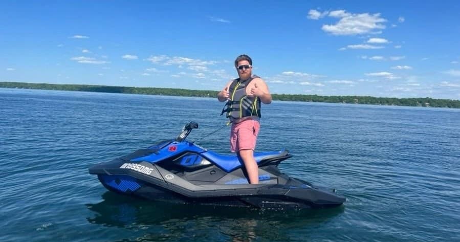 Rider standing on jet ski in open lake, adrenaline water riding