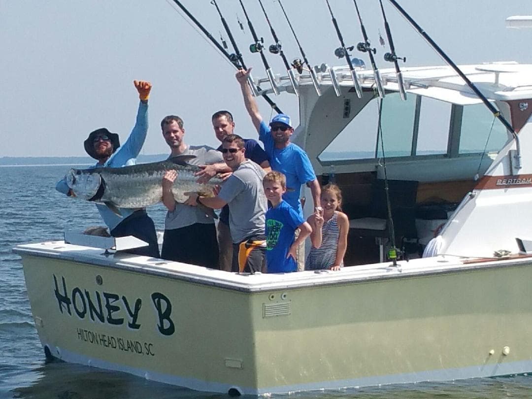 Charter fishing trip with anglers holding trophy fish on boat