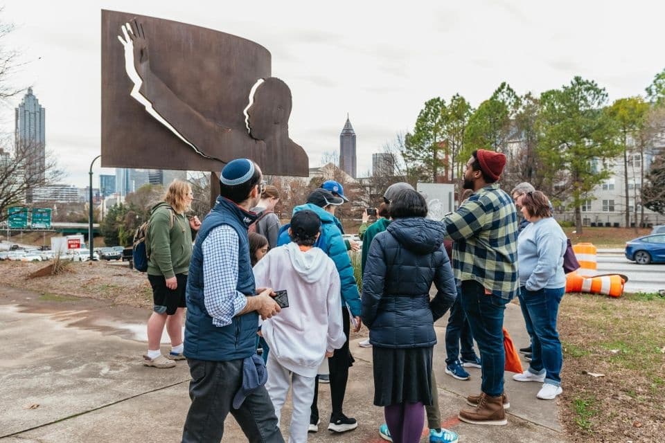 Guided food walking tour group exploring public art and streets