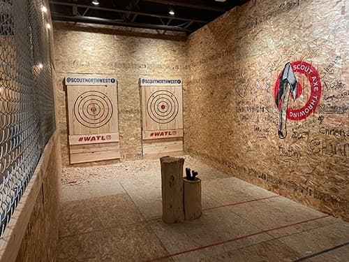 Axe-throwing lane with log stand and targets in indoor venue