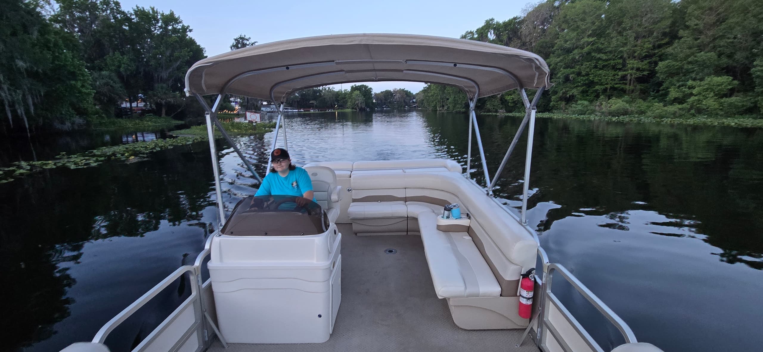 Pontoon boat cruising a calm Florida river, scenic canopy ride