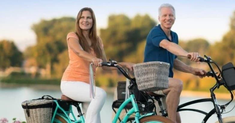 Couple riding cruisers by lakeside enjoying relaxed bike tour