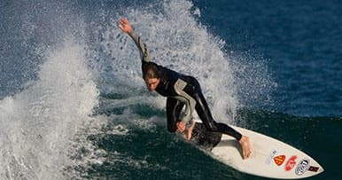Surfer carving a wave on coastal reef at Newcastle beach