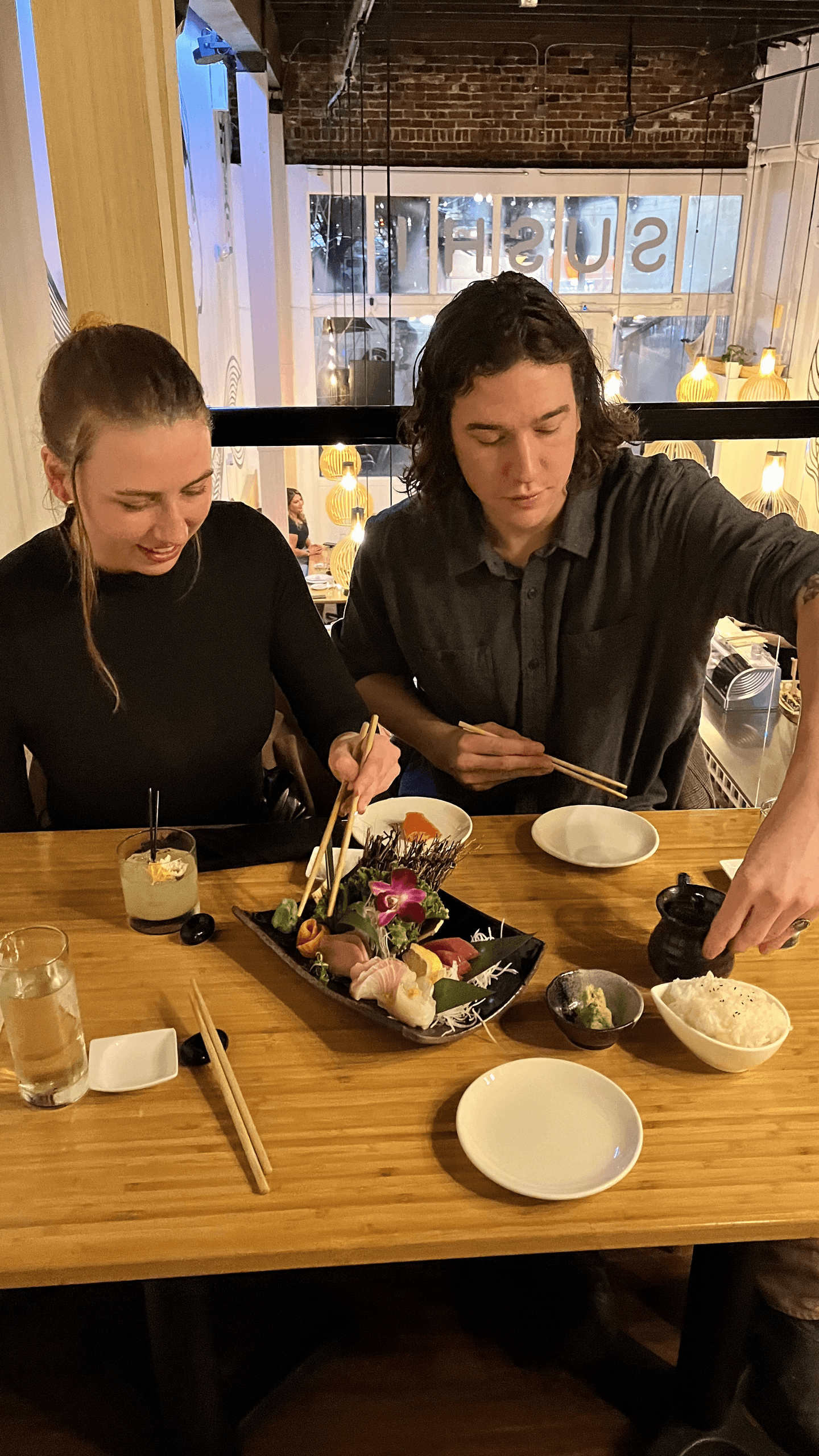 Friends sharing sushi platter at indoor Portland restaurant