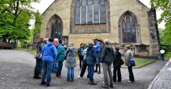 Small tour group gathered outside historic church in Edinburgh