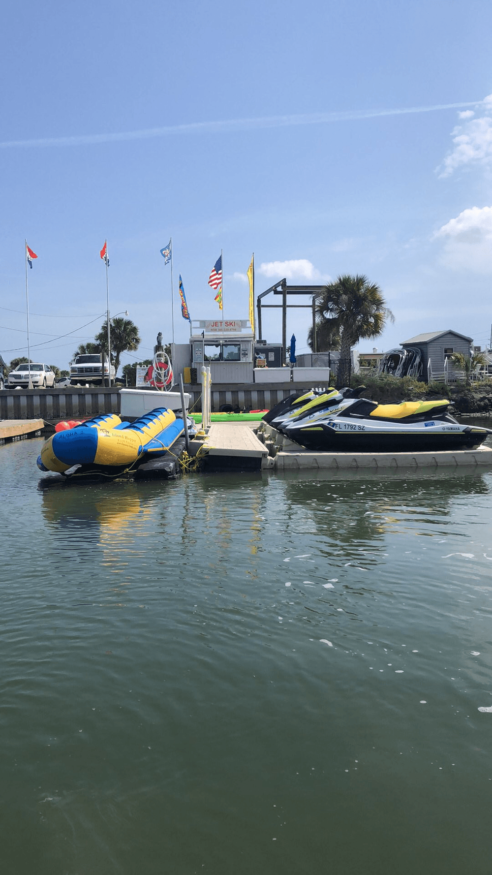 Docked jet skis and inflatable tow at marina on calm water