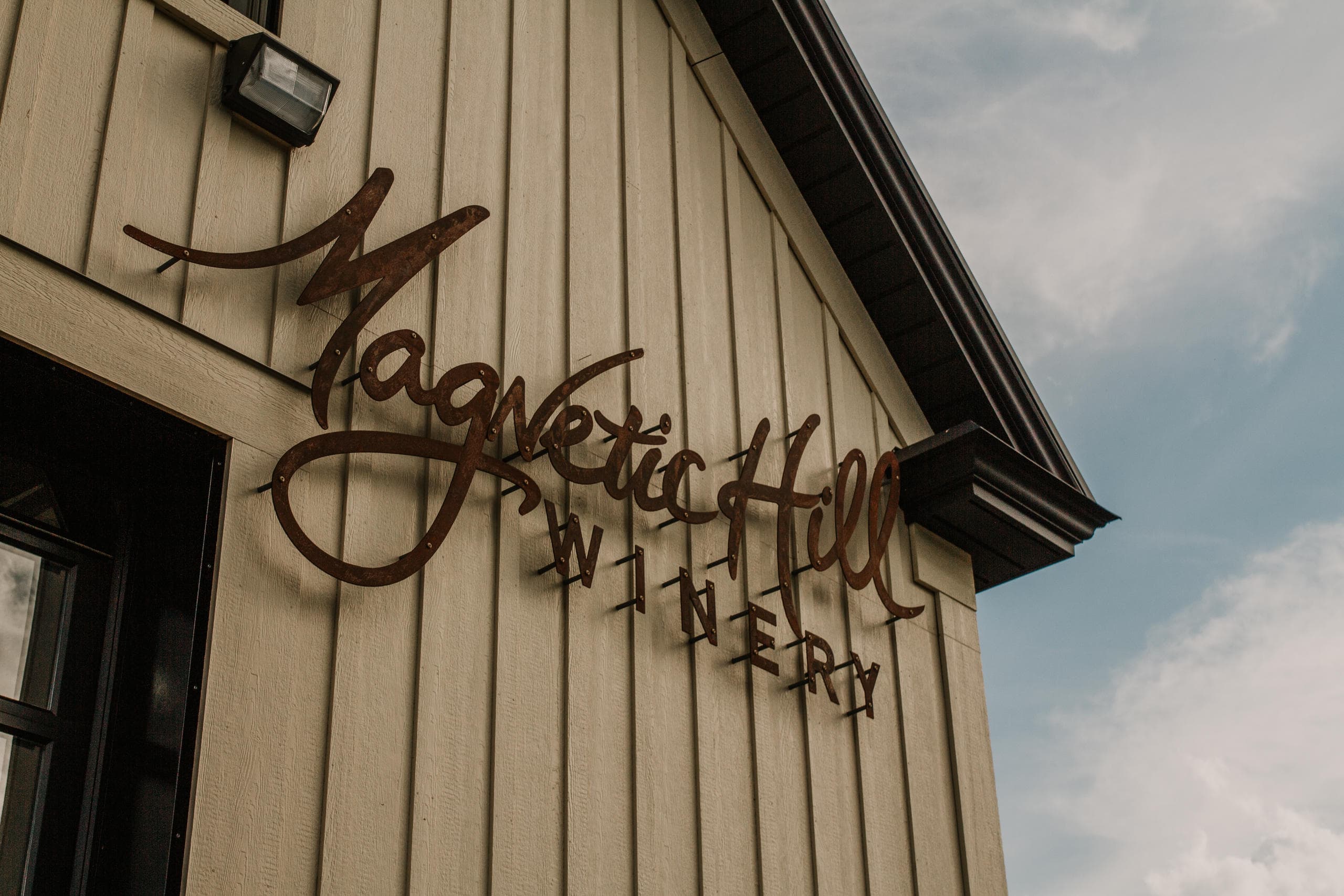 Magnetic Hill Winery wooden sign on exterior building facade