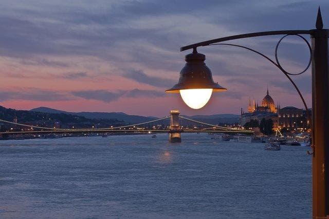 Riverside lamp and Budapest skyline at dusk along Danube, scenic walk