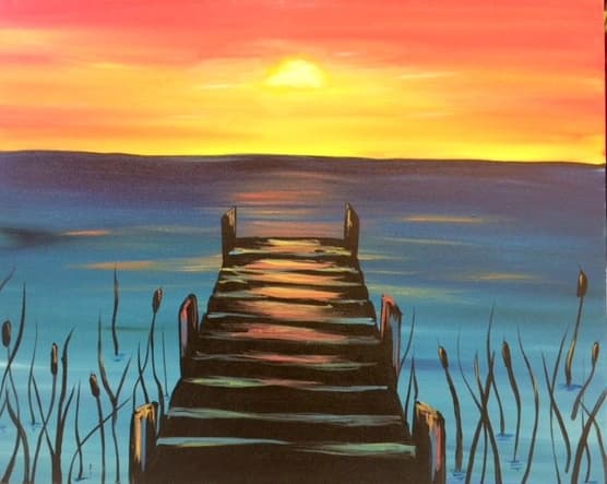 Sunset pier leading into reflective water at tranquil evening