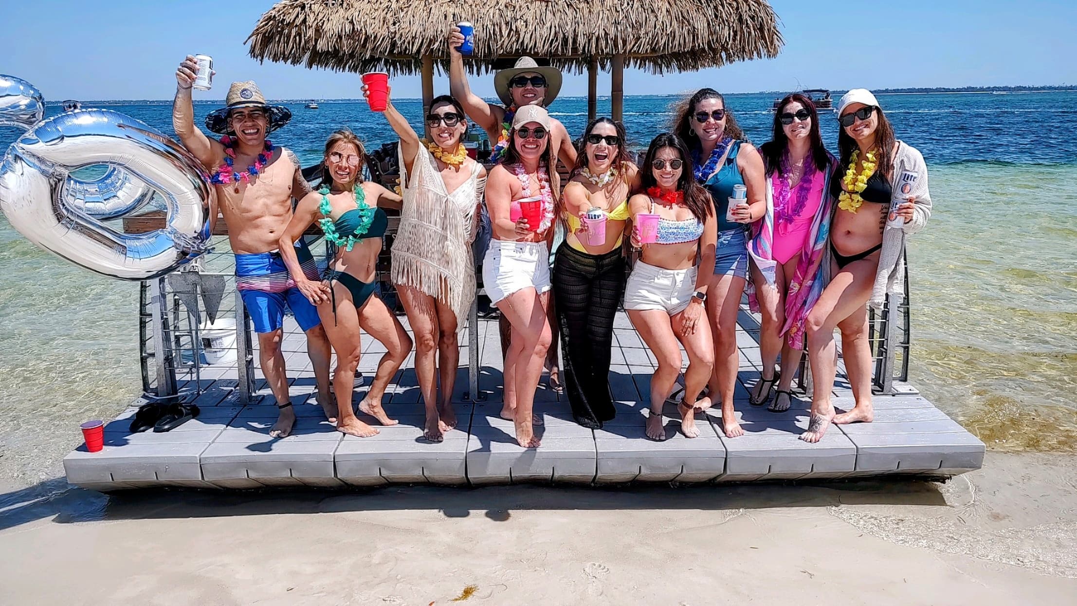 Friends partying on shallow sandbar with tiki raft
