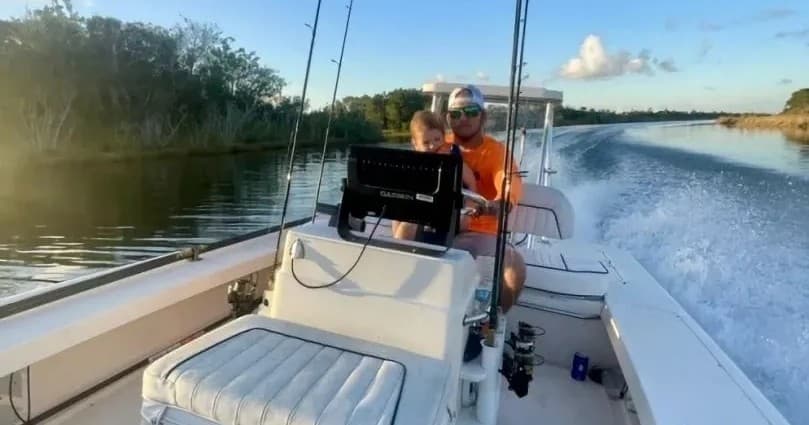 Fishing charter speeding along river with mangrove shoreline