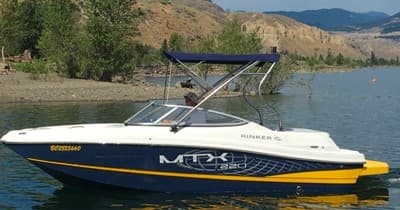 Bowrider speedboat cruising along scenic lakeshore, watersports ready