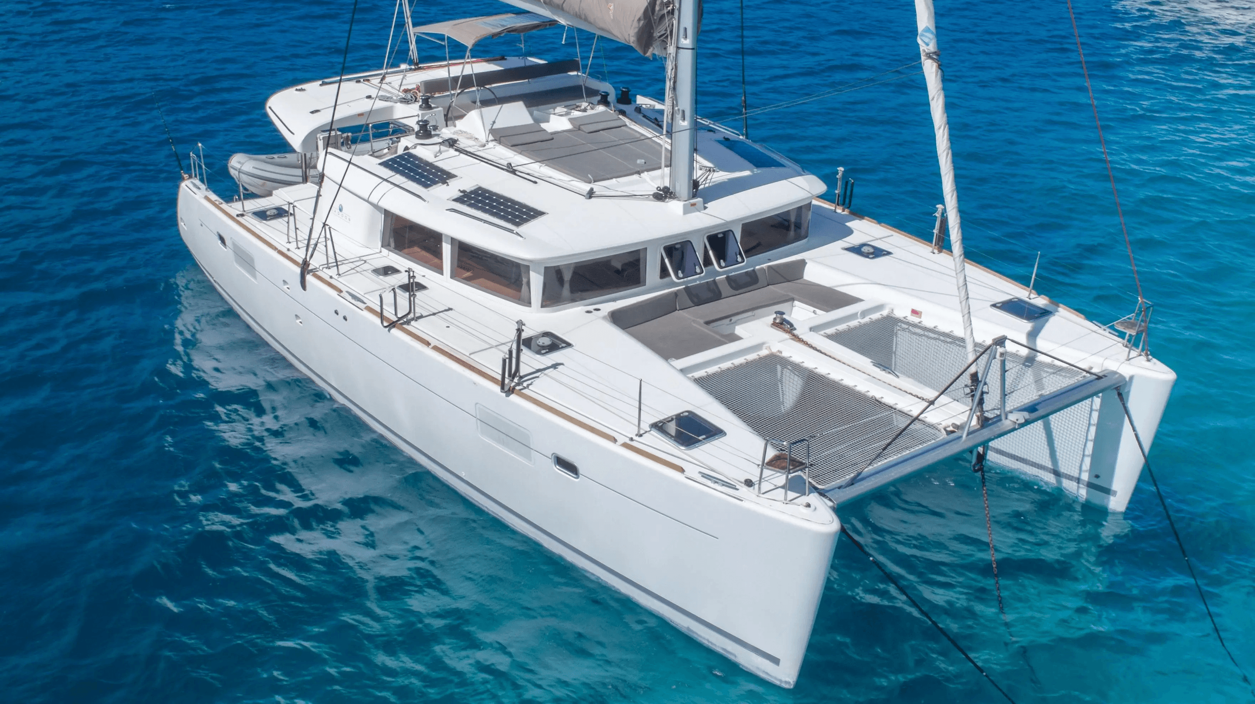 White catamaran yacht anchored in clear turquoise tropical waters