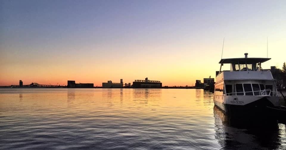 Ferry cruising at sunset across tranquil harbor waters